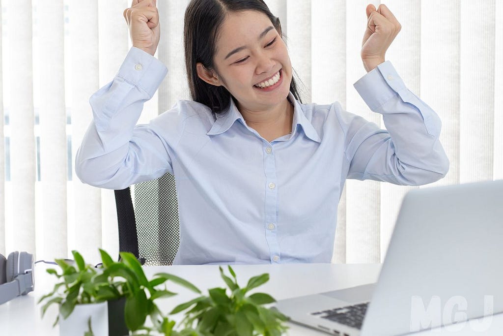 Person looking happy at their computer as if they’ve won something