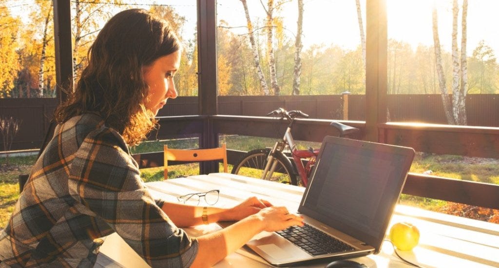 An entrepreneur working in a home office with a view of outside