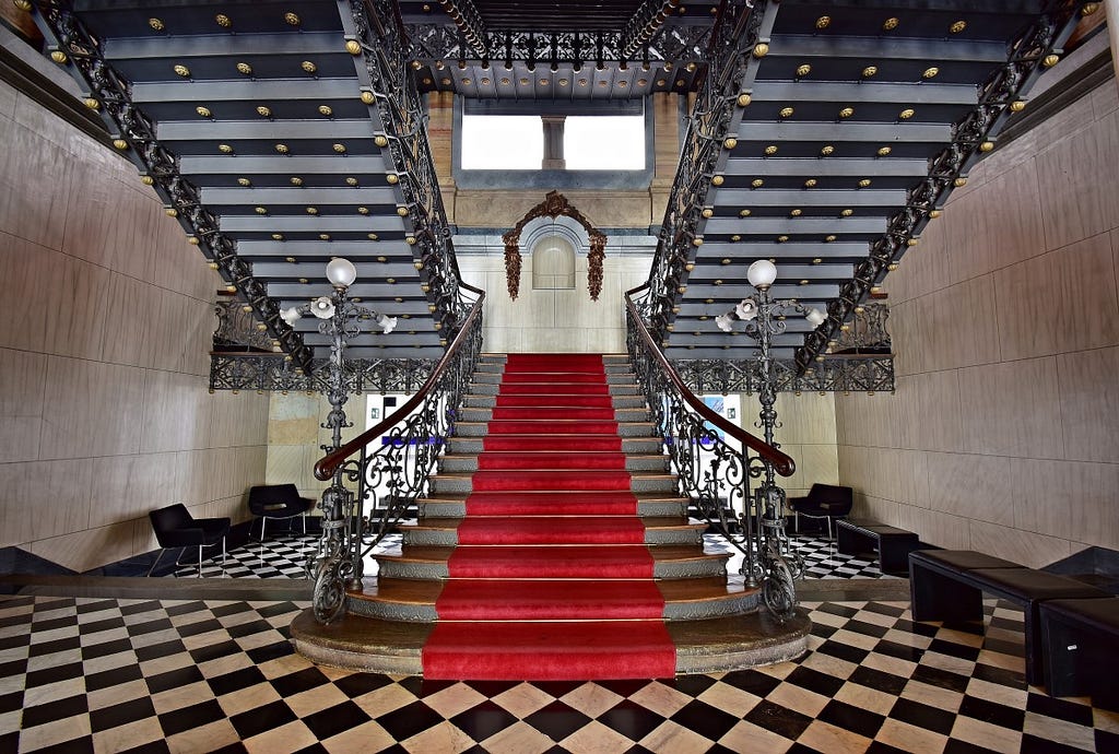 foto dentro do museu das minas e metal. da pra ver uma escadaria grande com um carpete vermelho