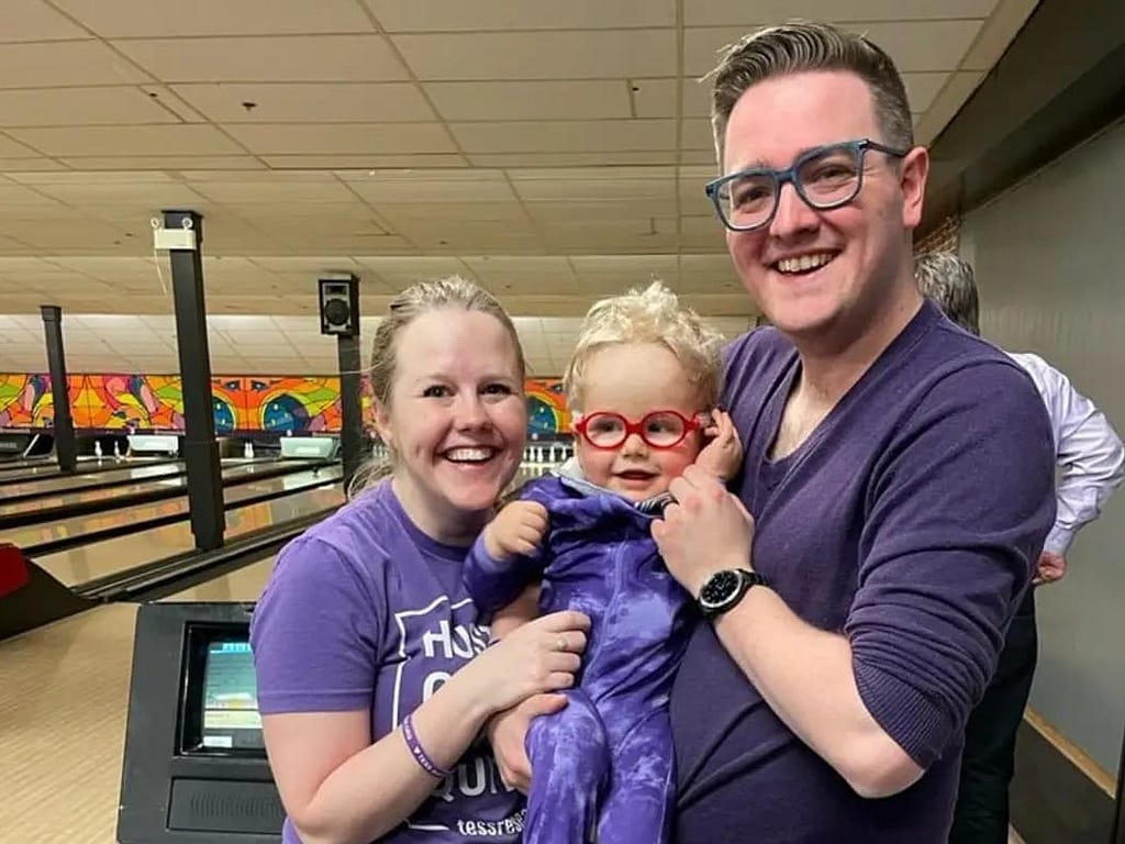 Parents Michael and Amber with Baby Rowan at a bowling alley — Invitae rare genetic disease testing