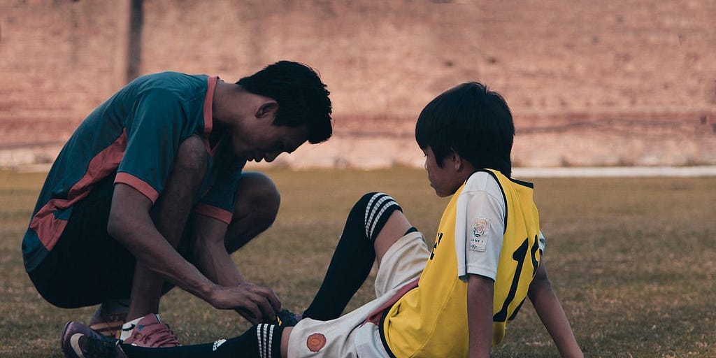 A soccer coach helping a young player