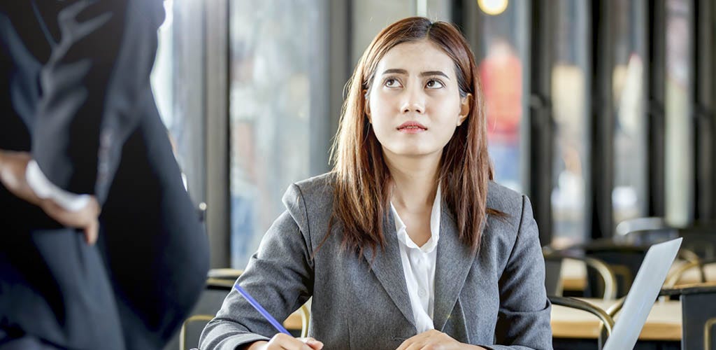 Frustrated employee looking up at boss