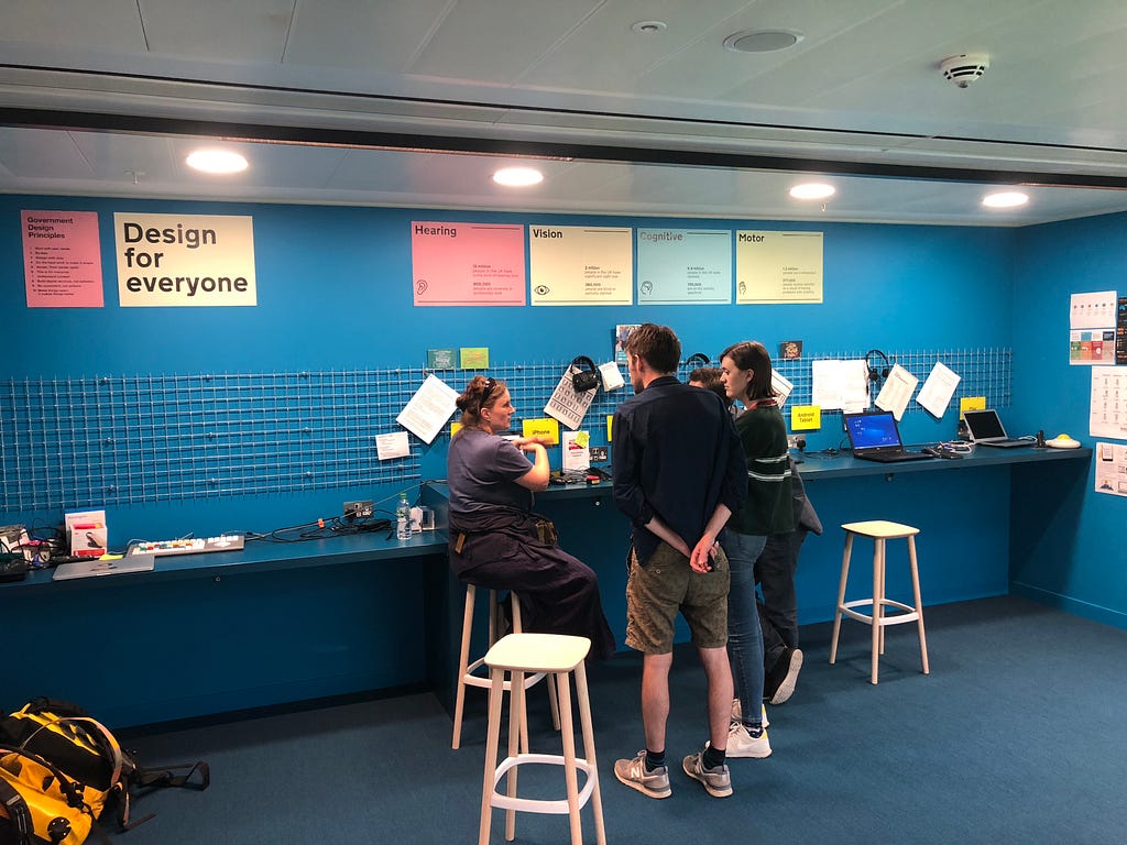 The Unboxed/GDS team having a conversation around a desk in the empathy lab.