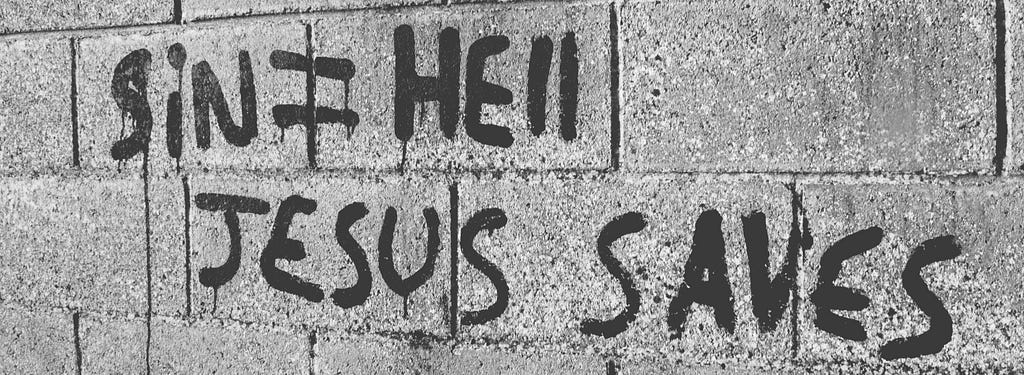 Sin = Hell , Jesus Saves printed with black paint on cinderblock wall