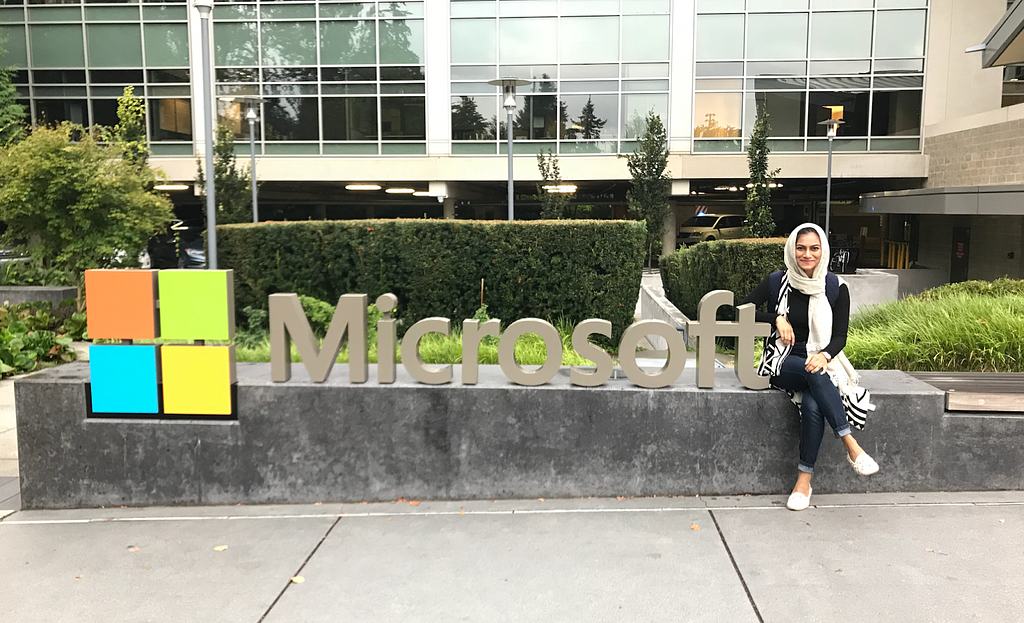 Anika poses next to a “Microsoft” sign and logo.
