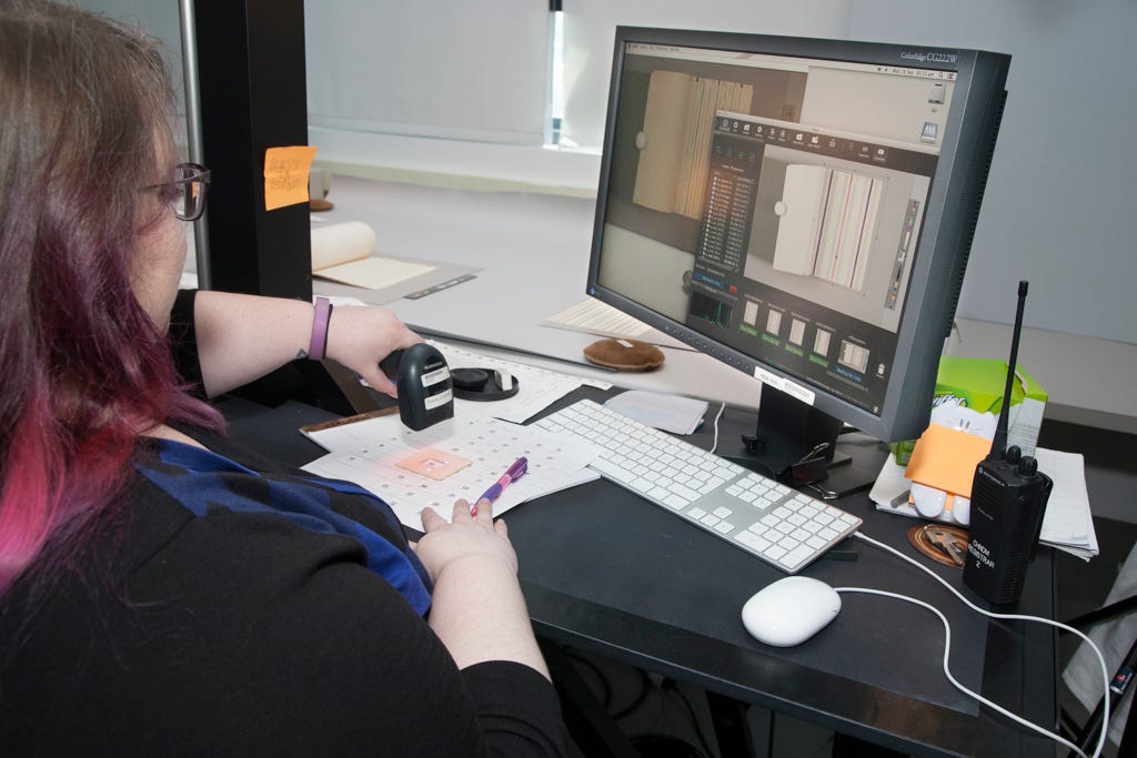 A technician scans a barcode on a coversheet during digitization. 