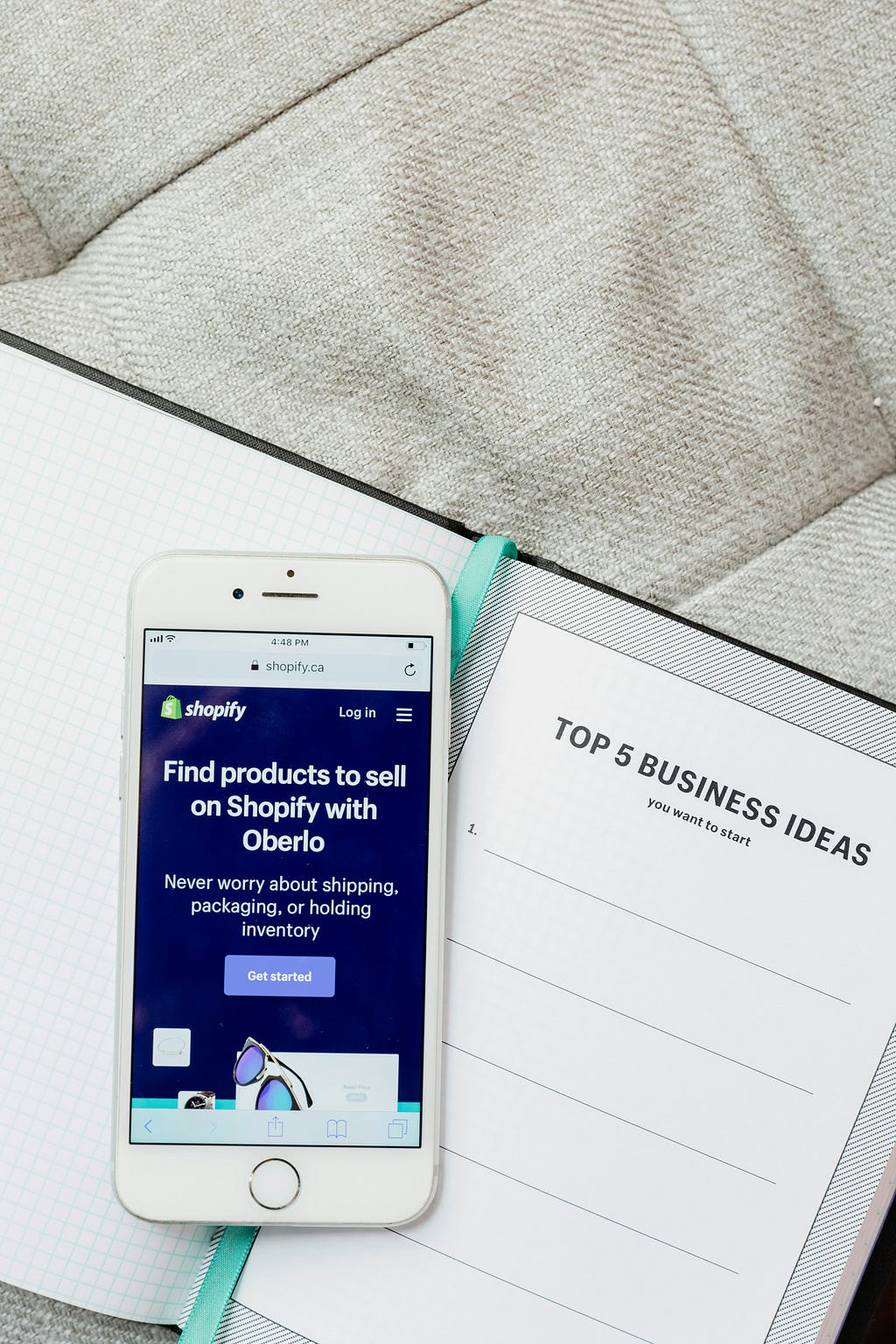 a phone on top of a book written ‘Top 5 Business Ideas’