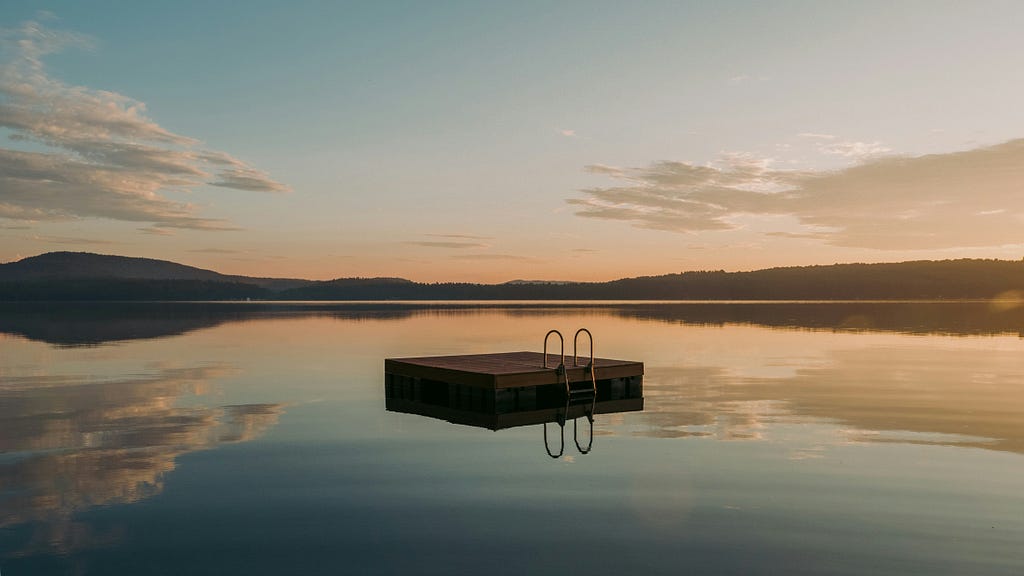 A pontoon sitting in the middle of a lake