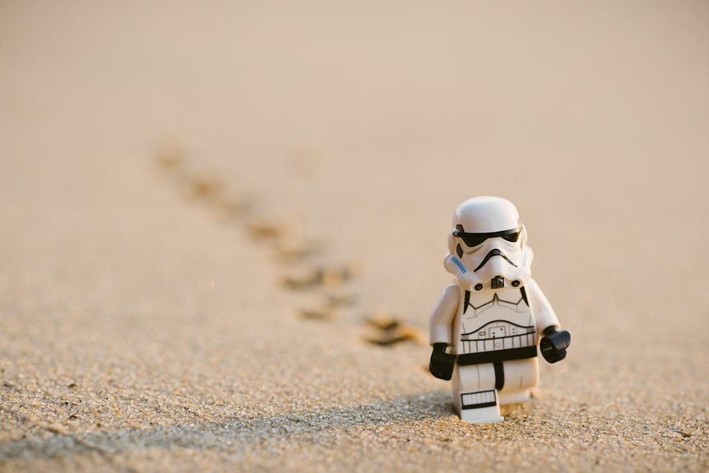 A Lego Stormtrooper walking alone in the dessert