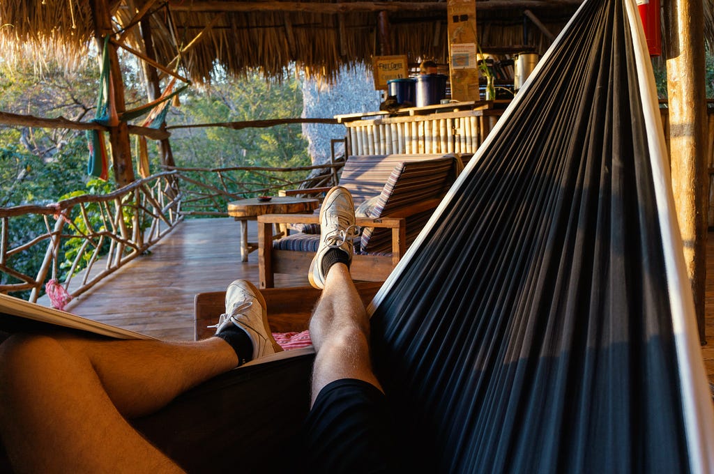 Person sitting in a hammock, with only legs revealed.