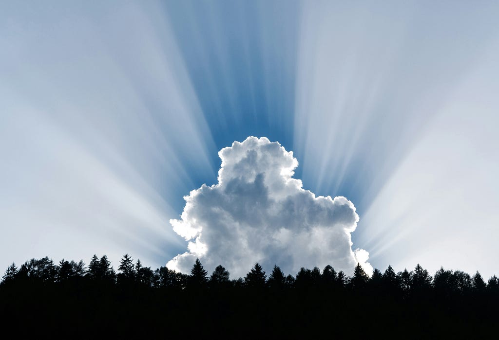 A cloudburst with rays of the sun pointing to heaven.