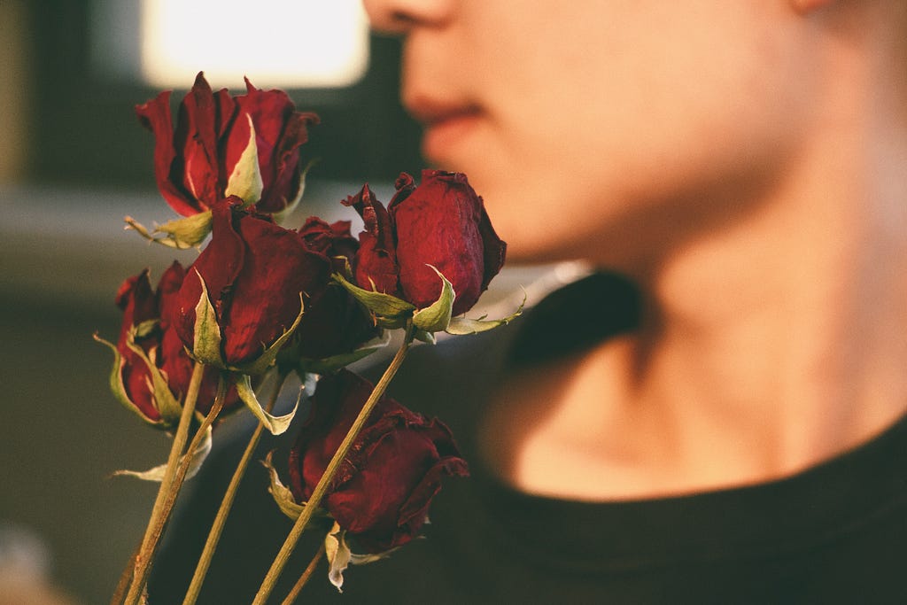 Dried roses, with someone in the background.