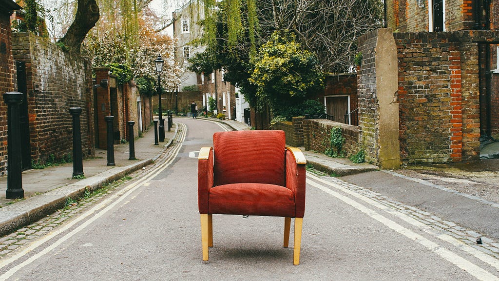 An old red sofa was placed in the middle of the road