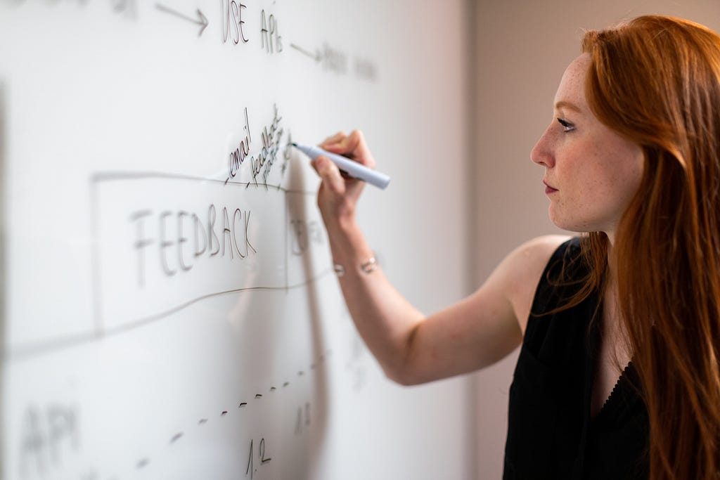 Woman writes on whiteboard