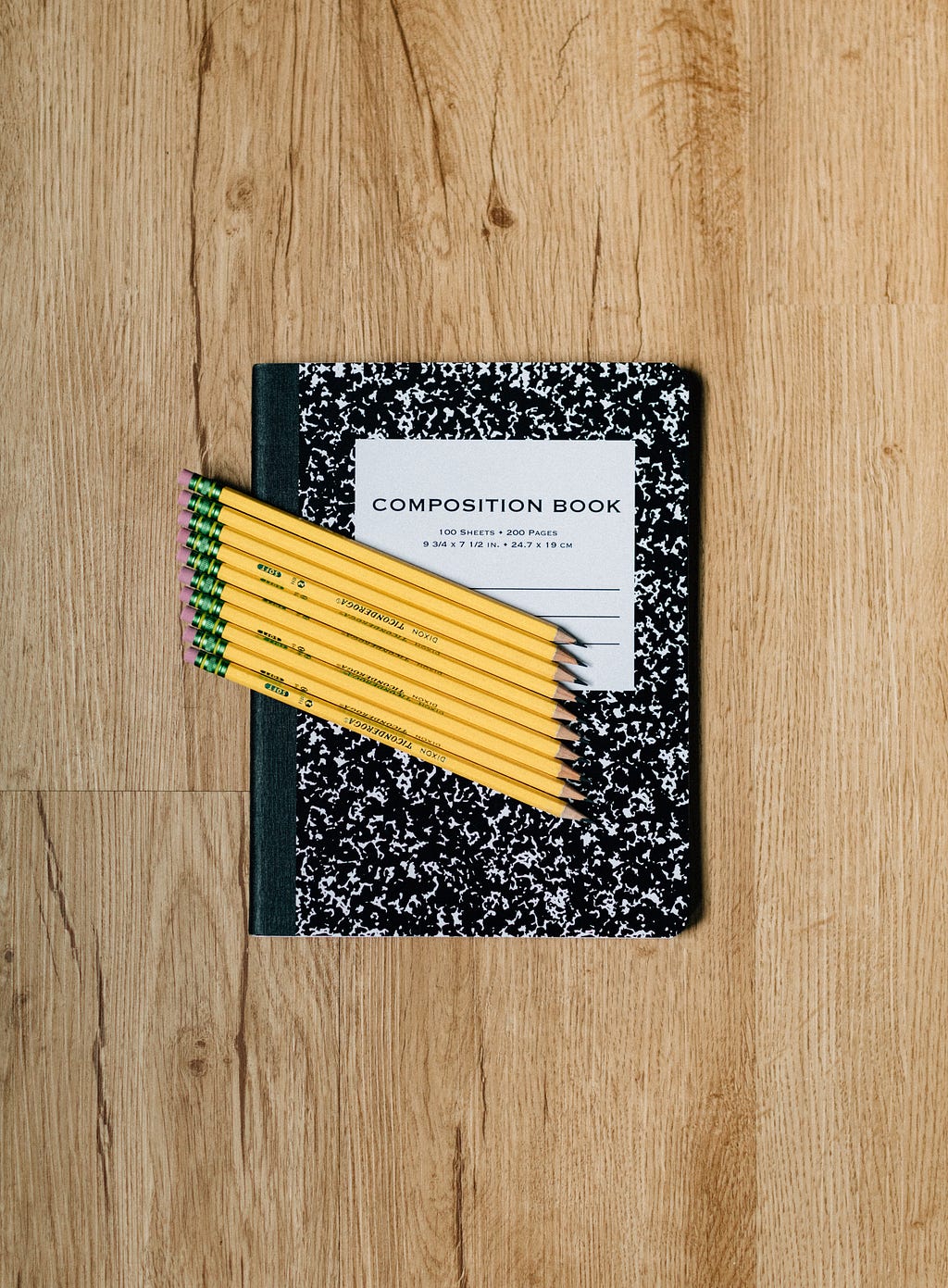 A composition book with pencils