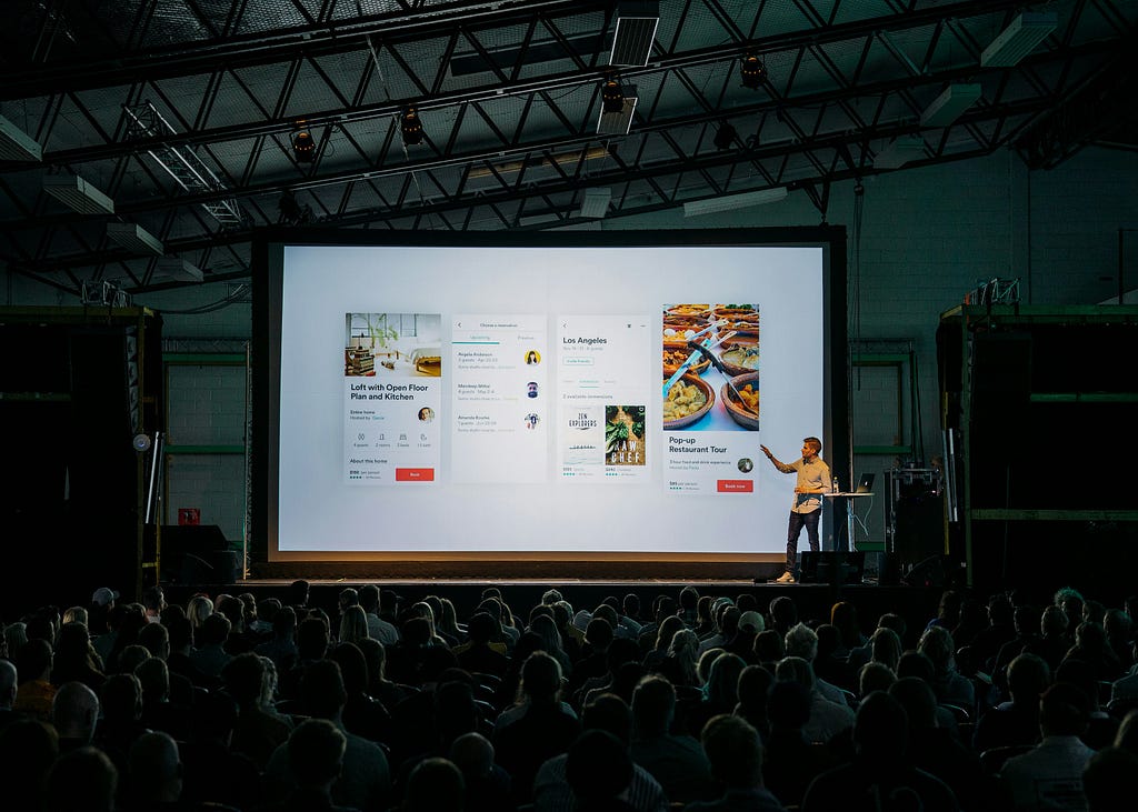 A speaker showing a presentation in front of a crowd