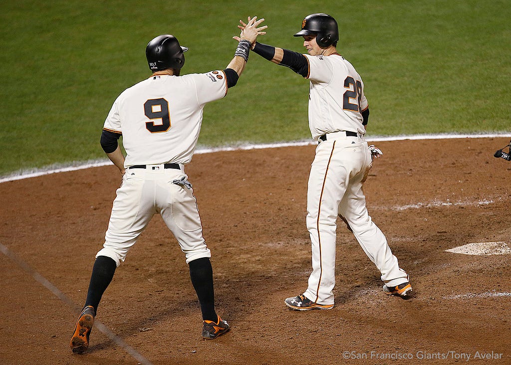 Brandon Belt and Buster Posey celebrate after scoring the tying and go ahead runs in the eighth inning.