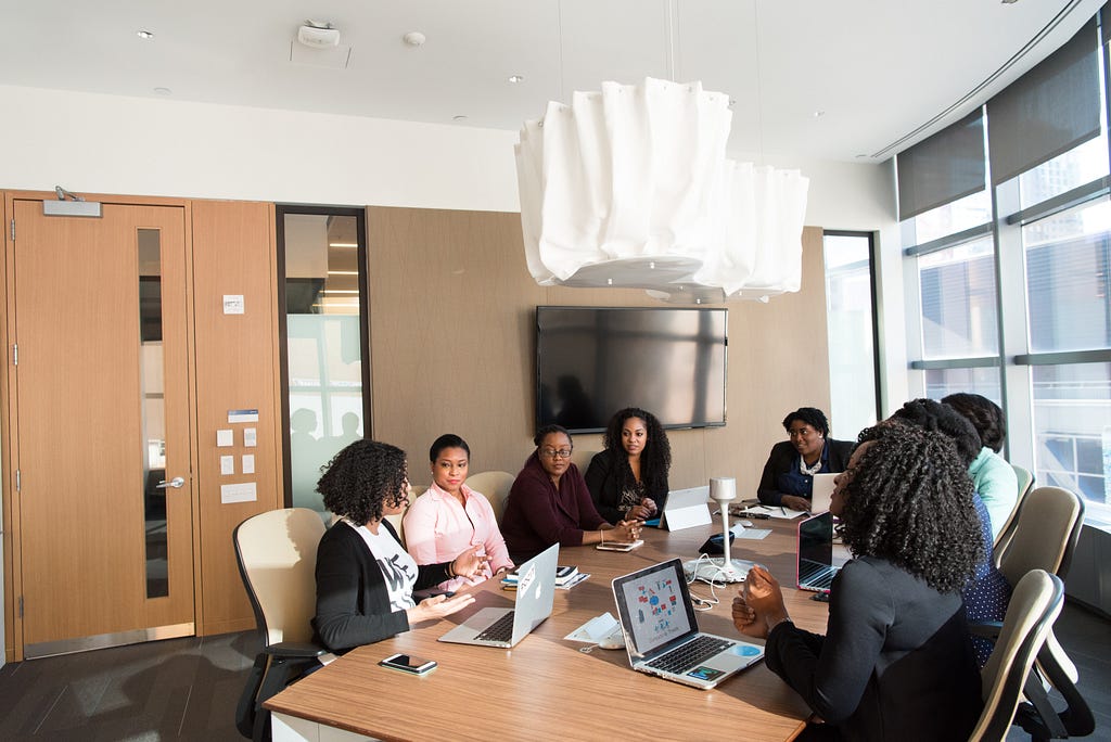 A group of women sitting in a meeting room having a discussion