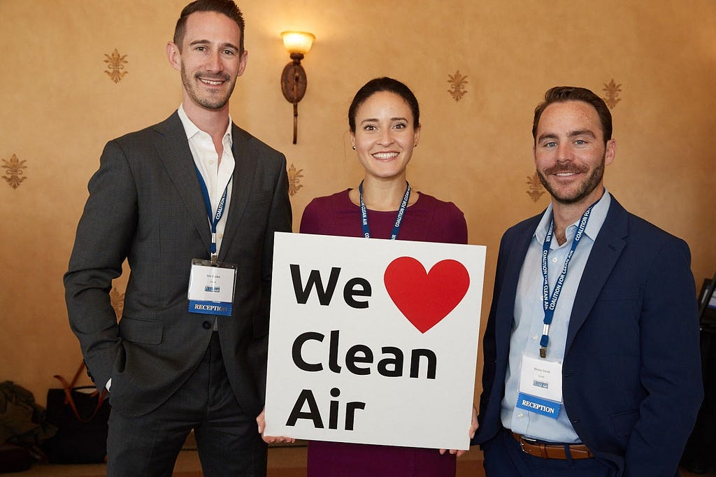 Eric Danko, Candice Plotkin, and Mason Smith of Cruise pose with a sign that reads, “We heart clean air.”