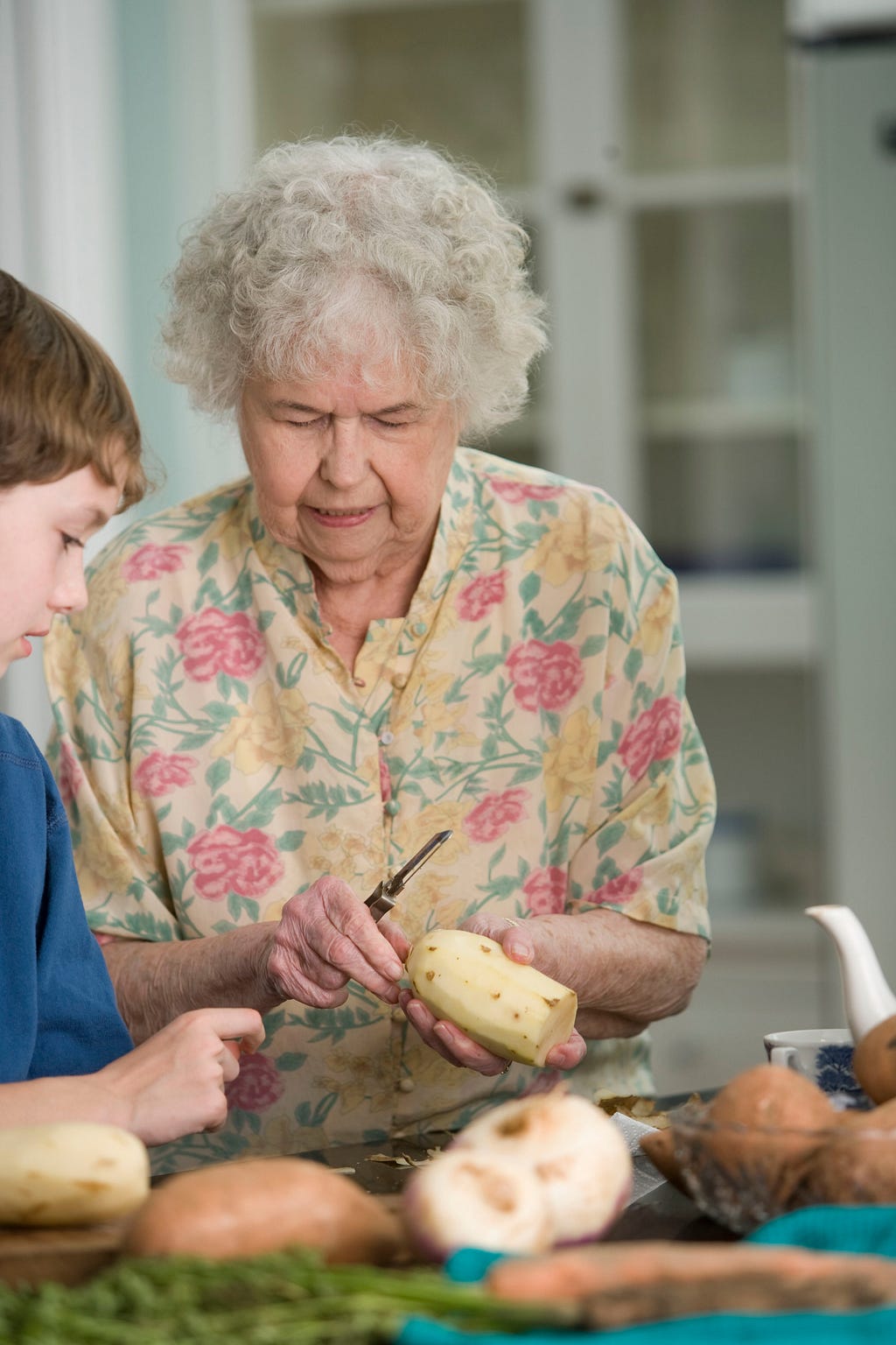 Grandmother teaching her grandson how to cook