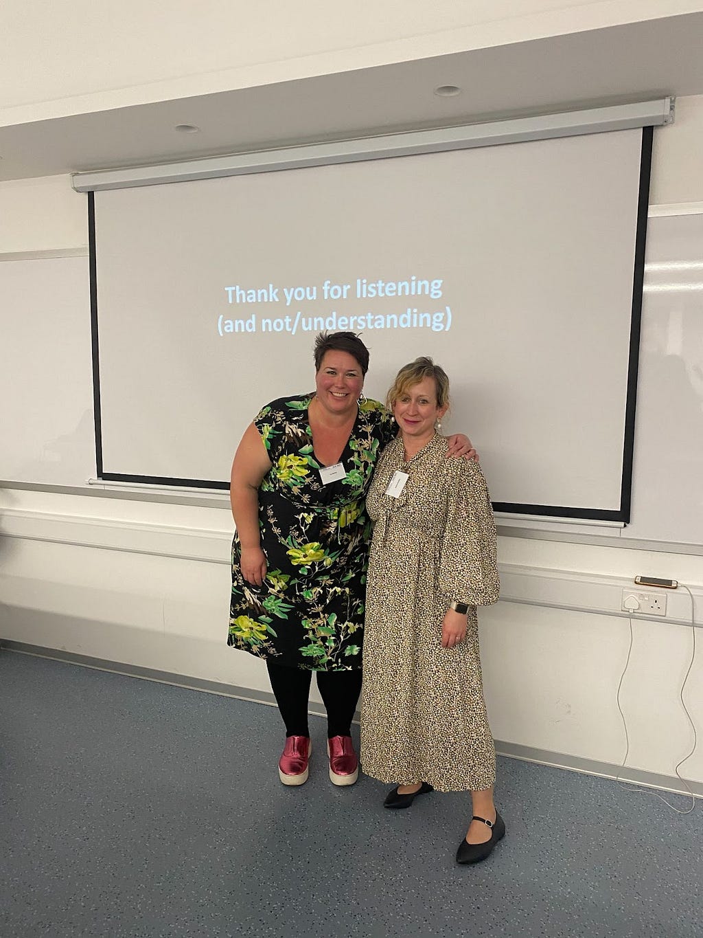 Image shows Dr Lou Harvey and Dr Jessica Bradley at the conference in a classroom