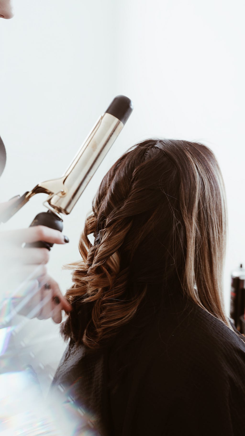 Hair salon business owner curling a client’s hair