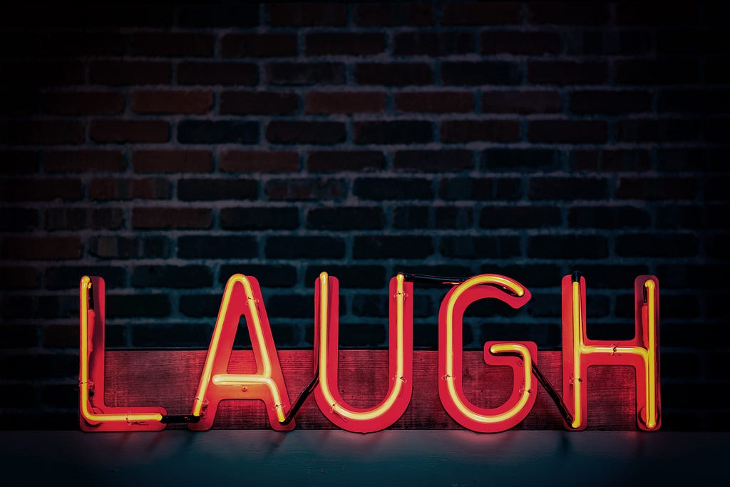 A big neon sign that says “LAUGH”