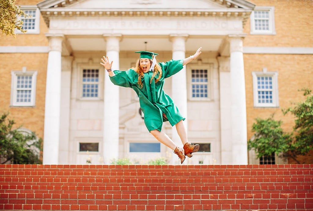 Girl graduate student, smiling and jumping over the stairs