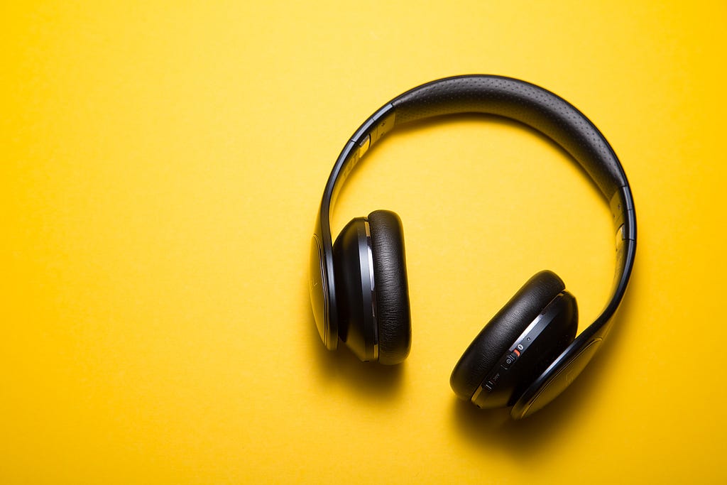 The picture shows a headphone against a yellow background.