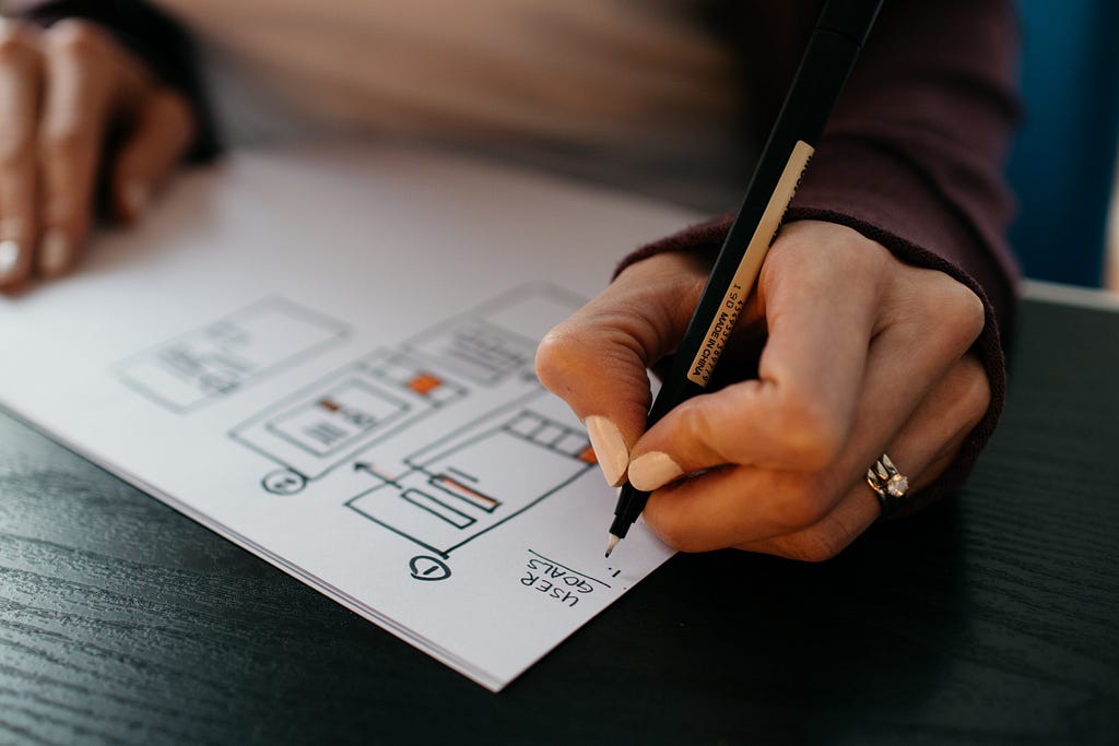 Lady making a plan with a black pen.