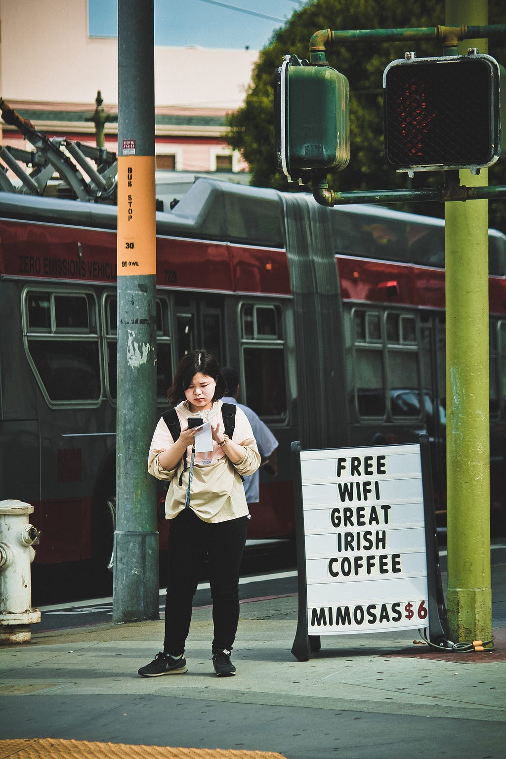 A woman standing on a street looking at her mobile phone