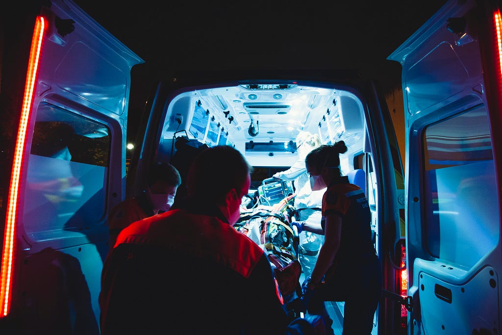 Inside of an ambulance with nurses attending to an emergency case.