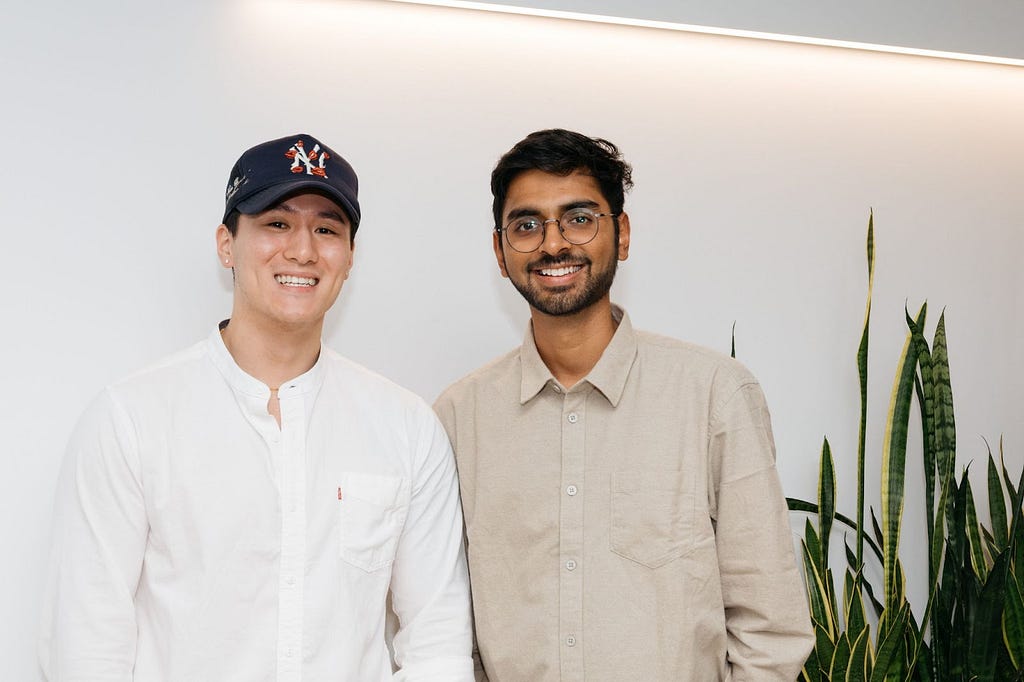 Jonathan Tai and his manager Vishal Krishnasami smiling and celebrating at an in office gathering in NYC.