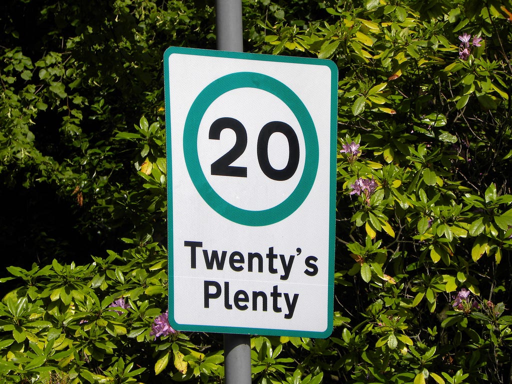 A speed limit sign saying twenty’s plenty.