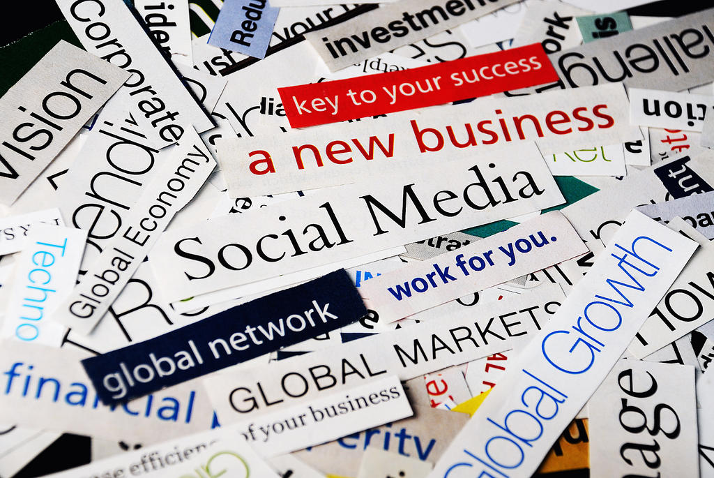 A collage of cut-out words and phrases related to business and social media, such as ‘Social Media,’ ‘a new business,’ and ‘Global Growth,’ arranged in a scattered manner.
