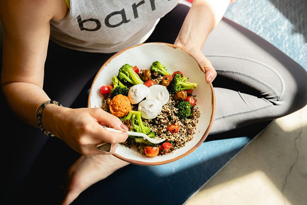 A women eating a bowl of healthy food