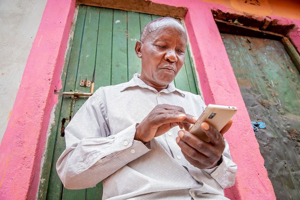 Farmer in Kenya accessing financial services from his phone