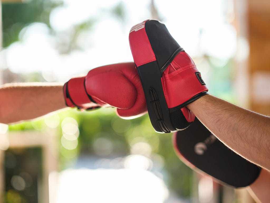 a hand blocking a punch depicting “rolling with the punches”