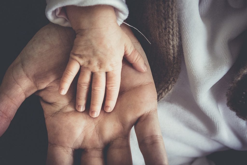 a baby’s hand on father’s palm