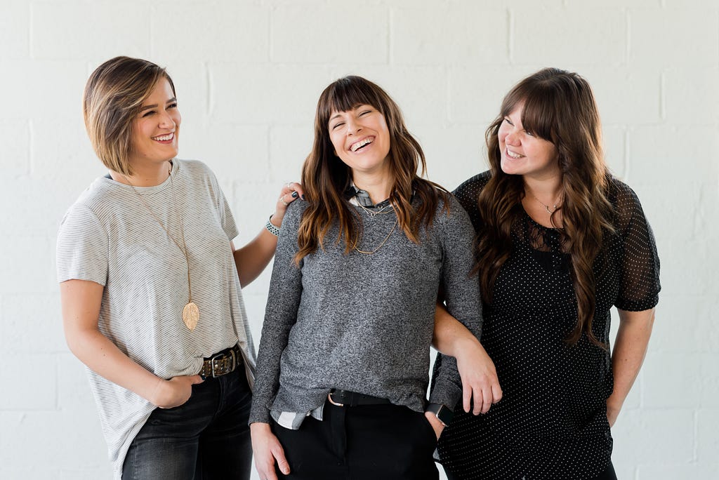 three women smiling/laughing together