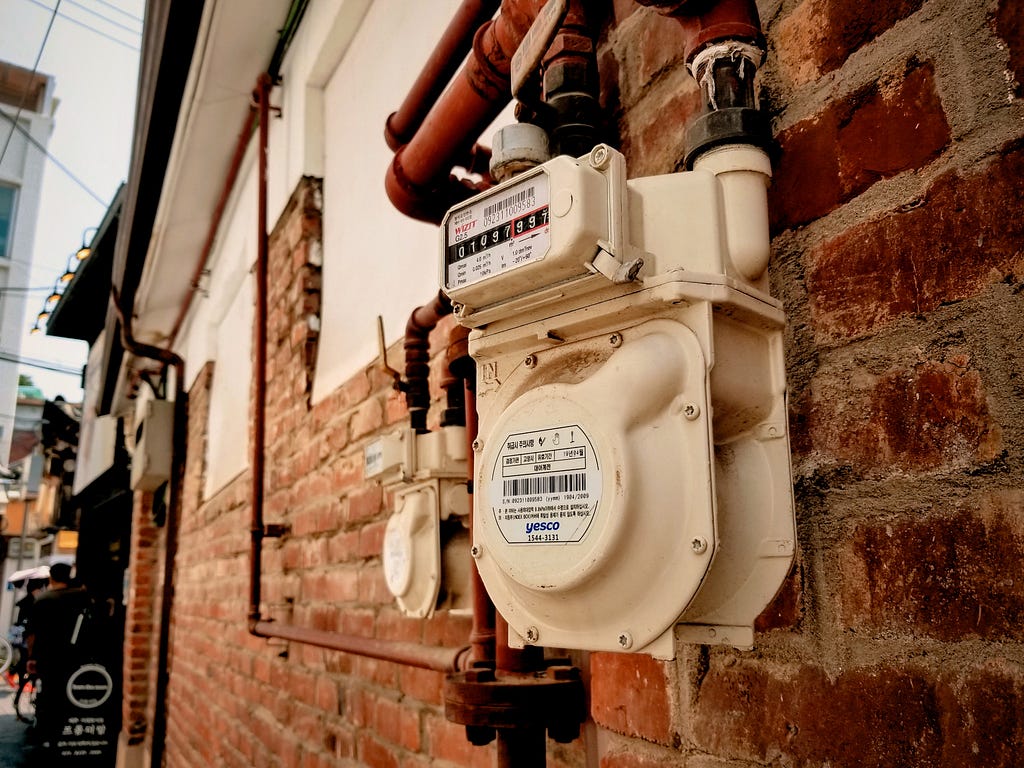 water meter outside a brick house