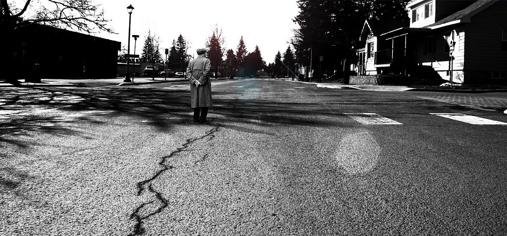 old man walking along town street