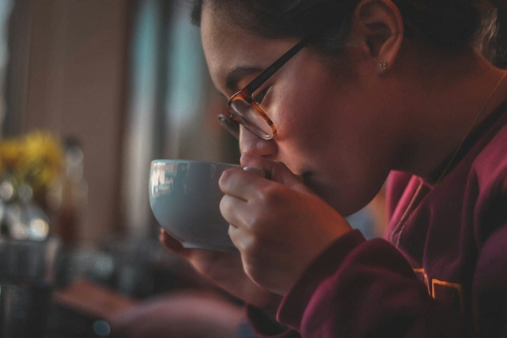 woman sipping on a cup of tea