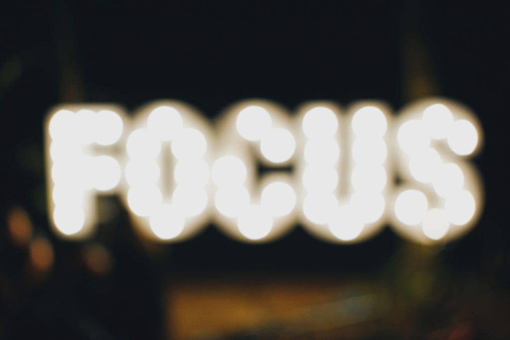 an out of focus photo of light up signs spelling the word ‘focus’