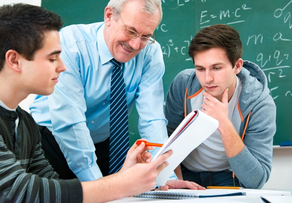 Image of a teacher assisting two students