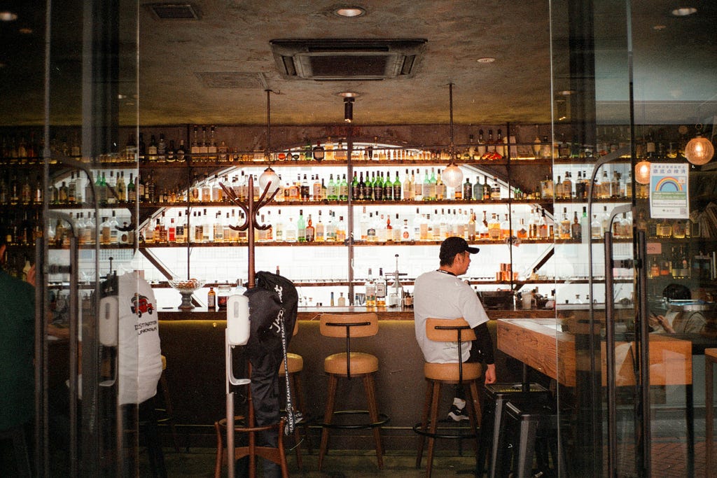 A man sitting alone at a bar counter.