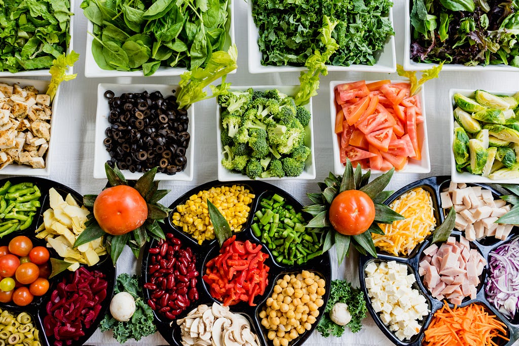 Numerous plates of fresh vegetables in assorted colors