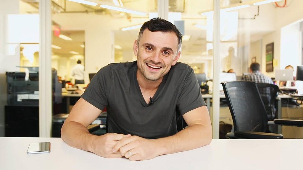 Gary Vaynerchuk sitting and smiling in his office.