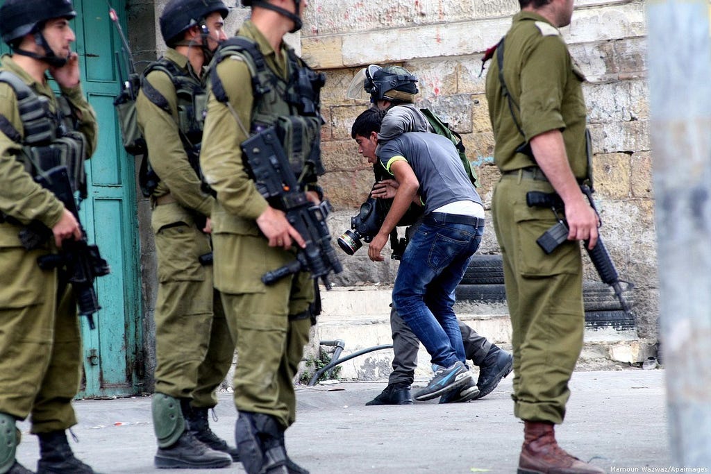 Soldados israelíes detienen a un joven palestino en la ciudad de Hebrón, en Cisjordania, el 22 de septiembre de 2017. (Foto: Mamun Wazwaz / Apaimages)