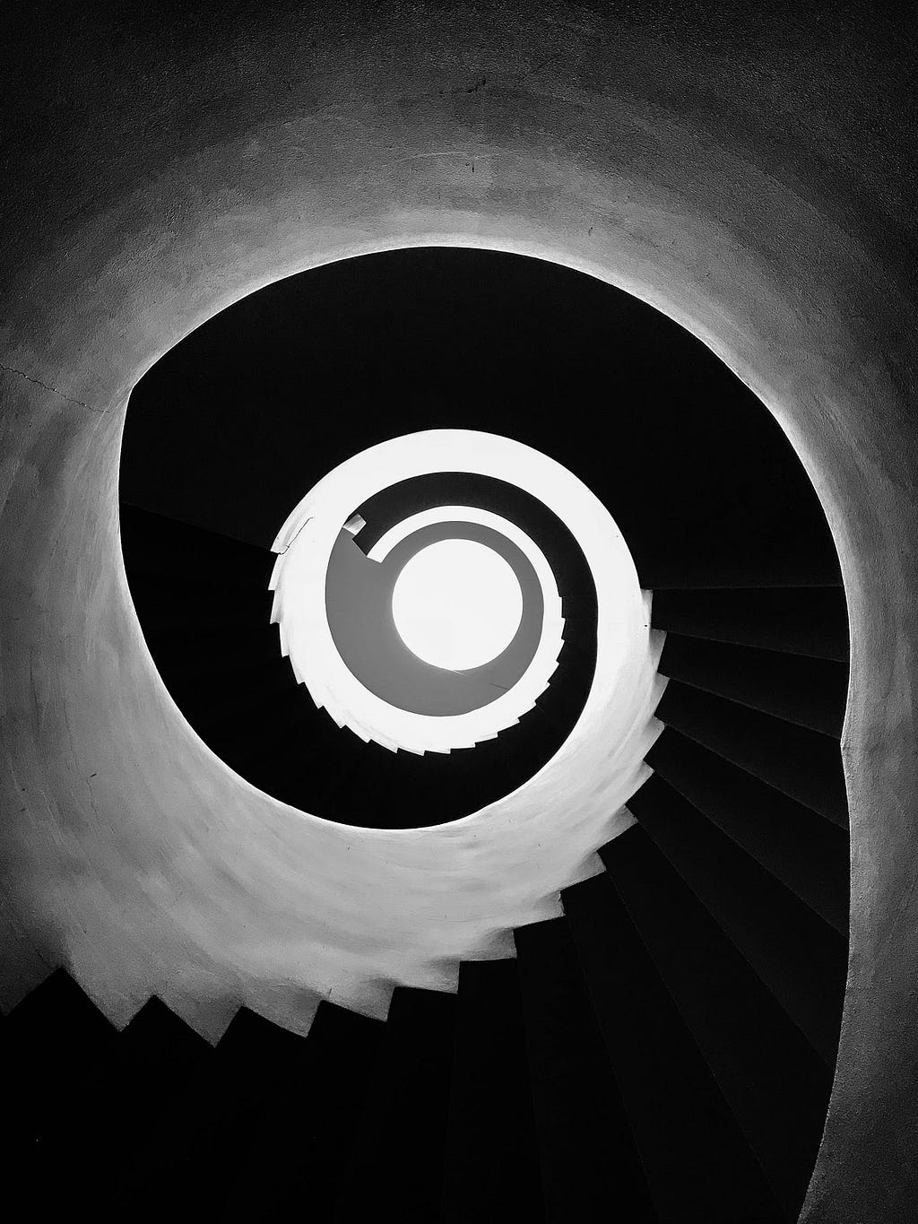 Optical illusion image looking down a spiral staircase